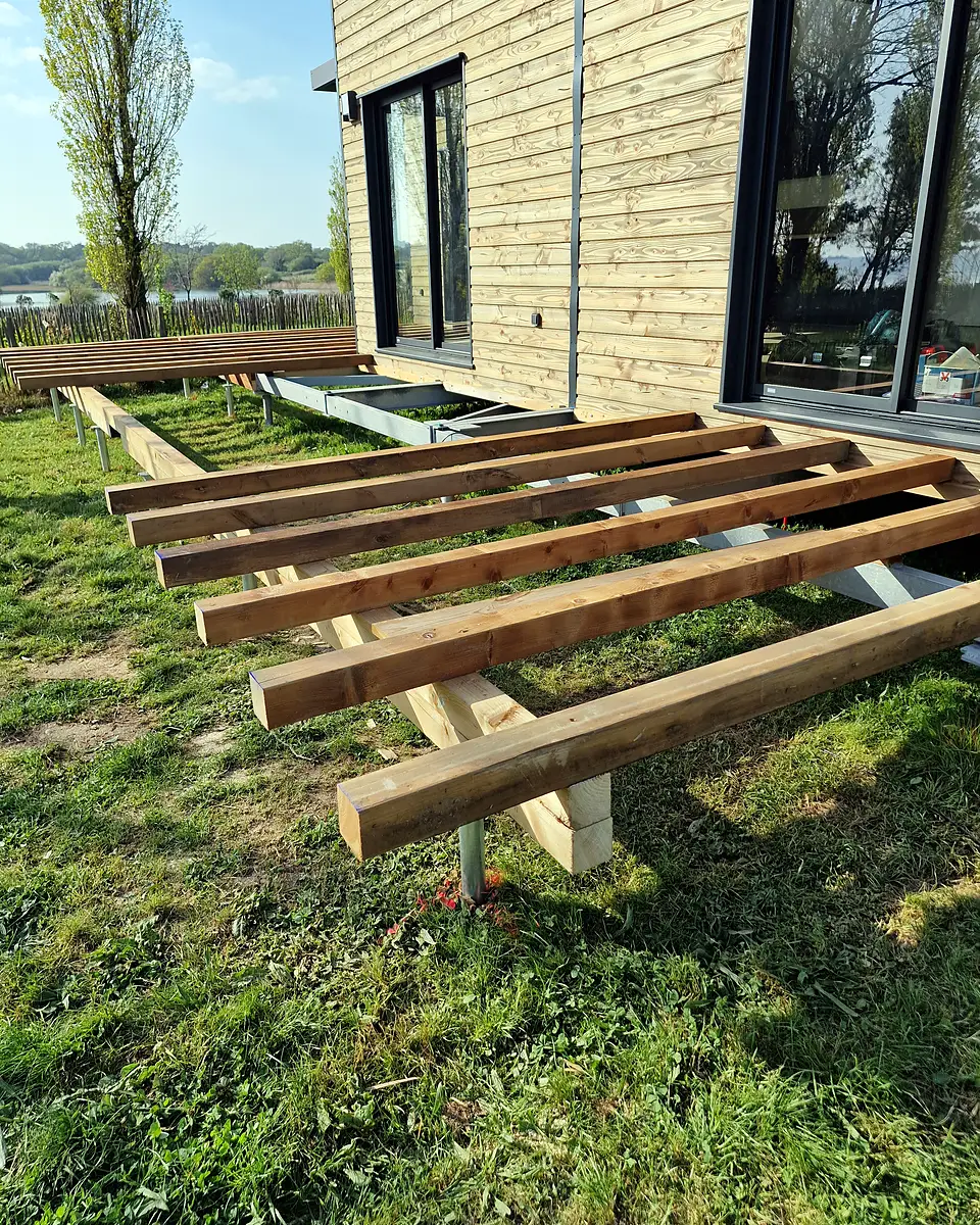 Poutres bois fixées sur les têtes des vis de fondation